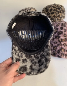Macro detail of plush leopard print baseball cap with 100% polyester fabric texture