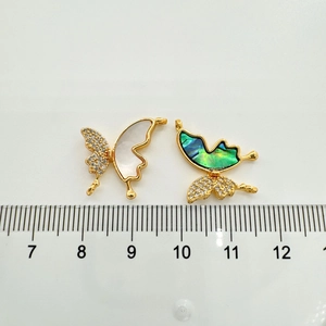 Detail showing butterfly charm dimensions with ruler, gold-plated shell and pearl inlay