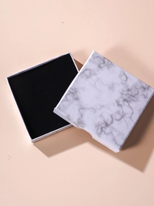 Detail of square marble pattern jewelry box with black velvet lining for rings and necklaces