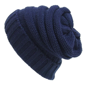 Dark blue chunky knit beanie hat in a slouchy style for winter warmth and ski wear