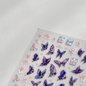 Macro detail of delicate purple butterfly and pink cherry blossom nail art stickers
