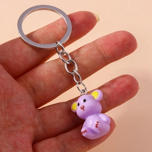 Close-up of cute purple resin bear keychain with yellow ears and silver ring detail