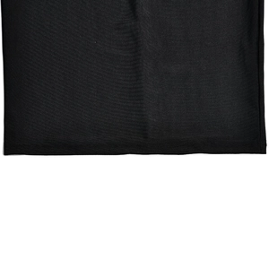 Détail de l'ourlet en maille noire avec coutures fines sur une robe à strass