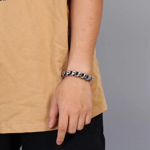 Détail des maillons à motif de croix sur bracelet chaîne en argent vieilli au poignet