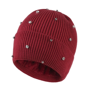 Detailed view of dark red knit beanie with thick fleece lining and pearl embellishments