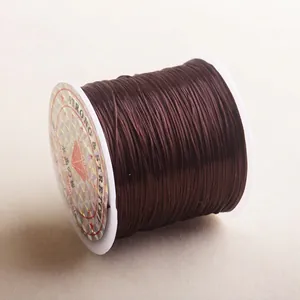 Macro view of strong brown crystal stretchy elastic cord for DIY jewelry on white spool