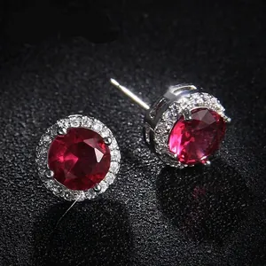 Macro shot of red round cut zircon earrings with halo micro-pave setting detail