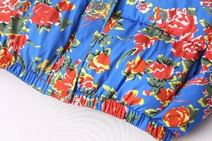 Detailed macro view of the elastic drawstring hem and hidden zipper on the floral jacket