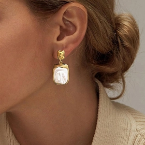 Elegant gold square baroque pearl earrings shown on model for a luxurious aesthetic