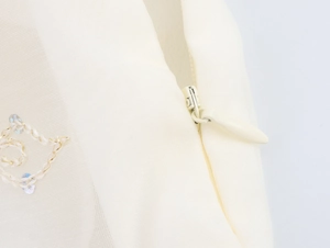 Détail de la fermeture éclair invisible sur robe à paillettes crème avec broderie