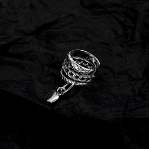 Detailed view of silver layered woven ear cuff with a dangling heart-shaped pendant