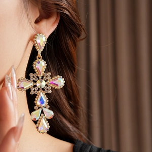 Close-up of vintage gold cross earrings with AB crystal rhinestones on model