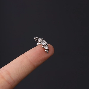 Detail of 16G surgical steel tragus stud with three graduated sparkling zircons