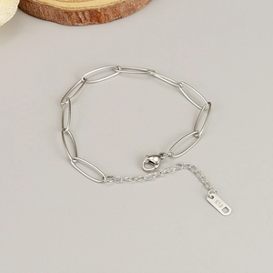 Detail eines silbernen Büroklammer-Kettenarmbands mit K18-Stempel und Karabiner