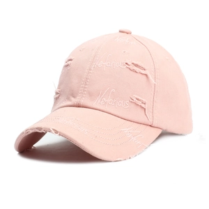 Close-up of pink distressed baseball cap with Nefarious embroidery and ripped details