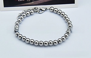 Detailed shot of polished stainless steel bead bracelet with adjustable lobster clasp