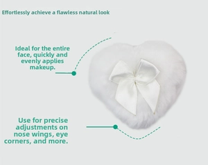 Detail view of heart-shaped white plush powder puff with satin ribbon for precise face makeup