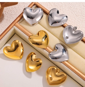 Detailansicht der polierten Herz-Ohrstecker in Gold und Silber in einer Schmuck-Displaybox
