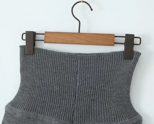 Détail du short en maille grise avec texture côtelée verticale sur un cintre en bois
