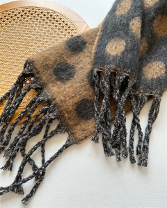 Detail of the soft cashmere-like fabric with large polka dots and tassel fringe