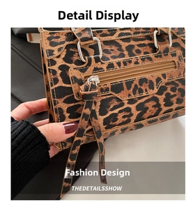 Dettaglio della borsa leopardata con cerniera in metallo e nappa decorativa d'argento