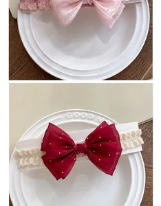 Detailed close-up of pink and burgundy baby lace headbands with mesh bows and pearls
