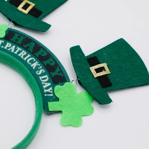 Detail of St. Patrick's Day headband with green shamrock and glittery leprechaun hat decor