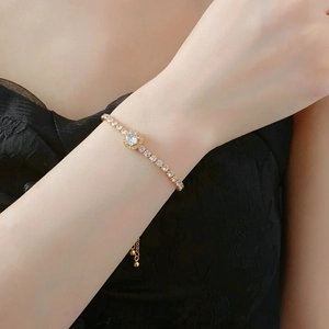 Détail du bracelet tennis doré ajustable avec halo de zircon sur le poignet d'un mannequin