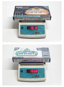 Detailed weight measurement of child musical keyboard toys showing 151g on digital scale