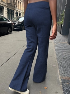 Rear view of deep blue flared yoga pants showing comfortable fit on city street