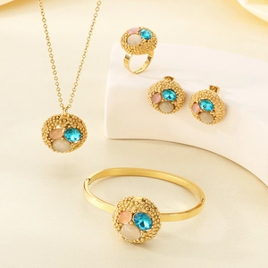 Detail view of gold-plated jewelry set with pink blue and beige zircon circular charms