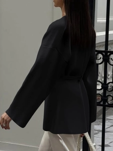 Side view of elegant black long-sleeve loose shirt with waist tie design and wide sleeves