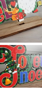 Close-up of wooden Christmas table decor with Joyeux Noël lettering and festive icons