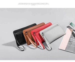 Flat lay of slim leather clutch purses in multiple colors with wristlets and metal zippers