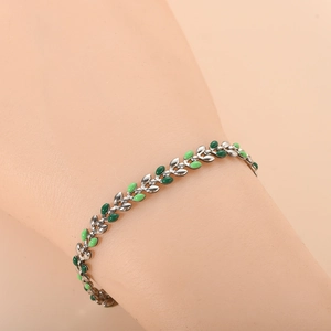 Detail of silver chain bracelet with green enamel leaf charms on a model wrist