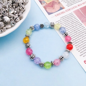 Rainbow cracked bead DIY bracelet with silver heart and cross charms on blue background