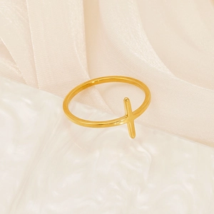 Macro detail of minimalist gold cross ring on elegant water ripple and silk background
