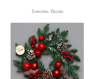 Close-up of Christmas wreath with pine needles, red berries, baubles and wooden sign