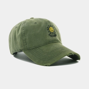 Detail of army green washed cotton baseball cap with sun embroidery and distressed brim