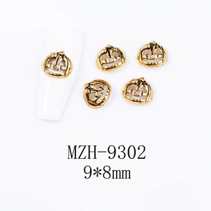 Macro shot of 9x8mm gold alloy pumpkin charm for Halloween nail art decoration