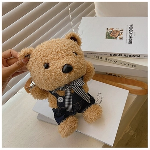 Detail of plush bear crossbody bag with denim overalls and checkered bow on books