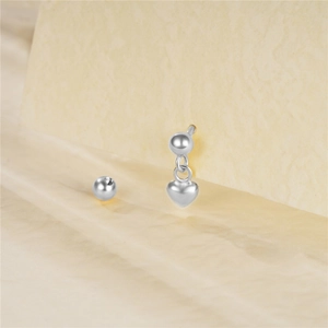 Detailed view of a silver heart charm ear stud with a spherical screw back closure