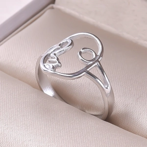Macro shot of silver hollow out face ring on champagne silk in a jewelry box