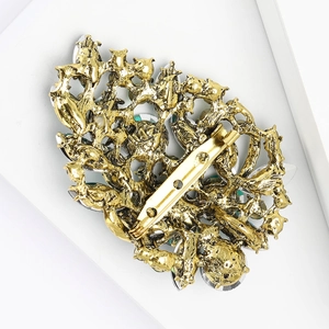 Detailed back view of alloy brooch with safety pin clasp and hollow vintage gold texture