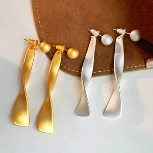 Irregular twisted metal drop earrings in gold and silver finish with matte texture