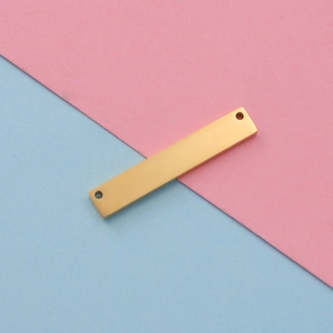 Close-up of a gold mirror-finish stainless steel rectangular tag with double holes