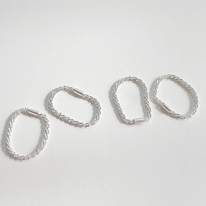 Detail shot of four-piece S925 sterling silver rings with spiral spring texture on white base