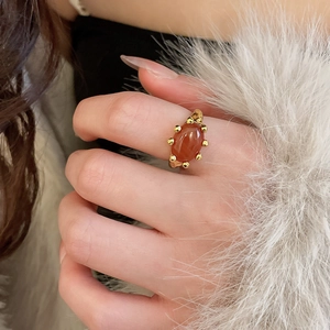 Close-up of a vintage gold-plated oval carnelian stone ring on a white fur background
