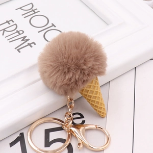 Detail view of a fluffy brown faux fur ice cream cone keychain with golden metal hardware