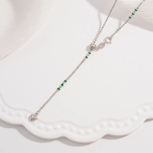 S925 sterling silver necklace with green beads and heart pendant on white silk background